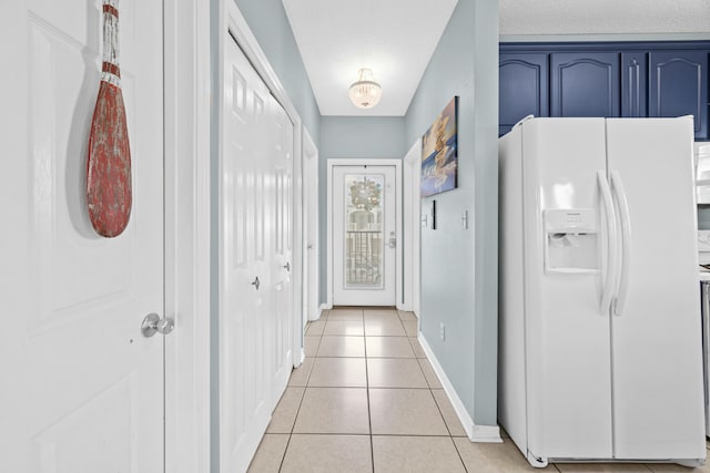 hall featuring light tile patterned floors and baseboards