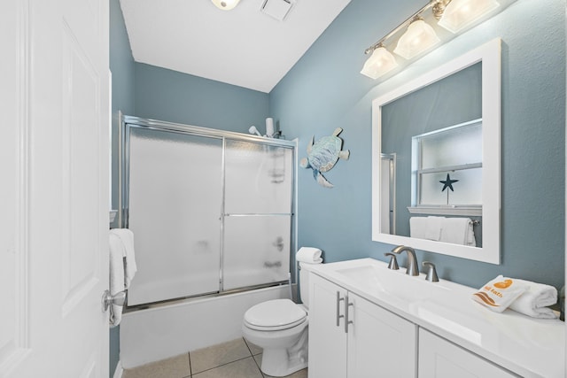bathroom featuring vanity, bath / shower combo with glass door, tile patterned floors, toilet, and visible vents