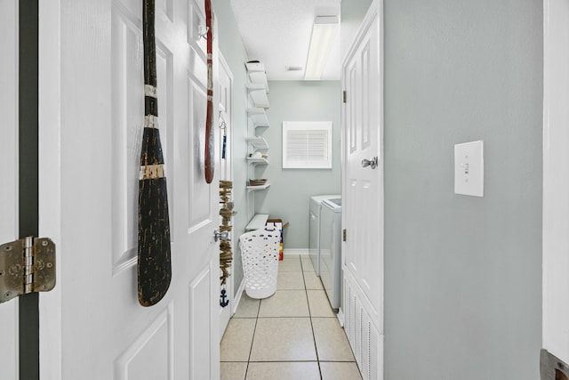 clothes washing area featuring light tile patterned floors, laundry area, visible vents, baseboards, and washer and dryer