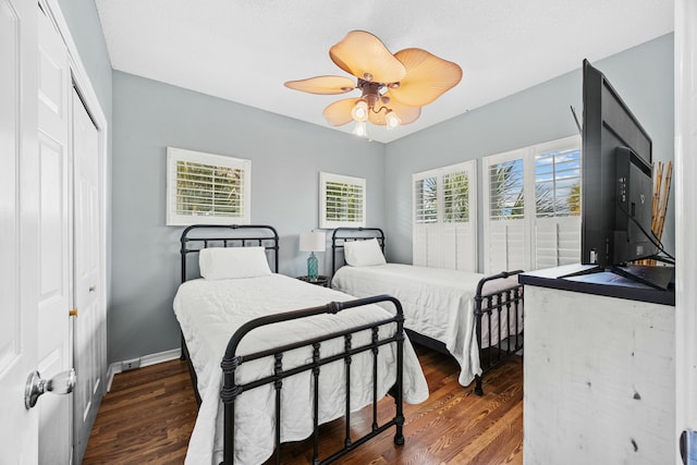 bedroom featuring wood finished floors, ceiling fan, baseboards, and a closet