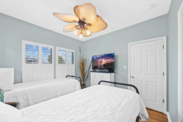 bedroom with baseboards, wood finished floors, and ceiling fan