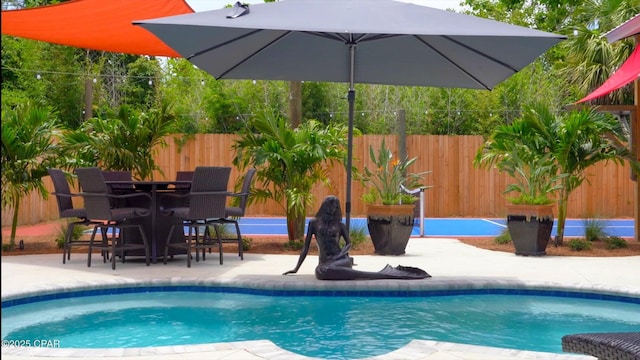 view of swimming pool featuring fence and a patio