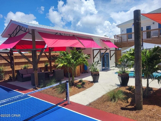 view of community with fence, outdoor lounge area, and a patio area