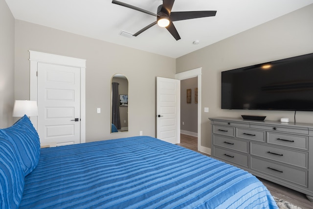 bedroom with visible vents, baseboards, ceiling fan, and wood finished floors