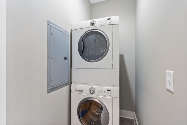 laundry room featuring stacked washing maching and dryer and electric panel