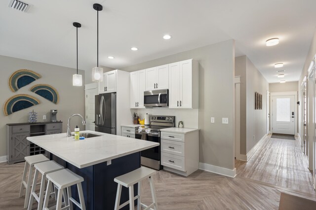 kitchen with visible vents, a sink, baseboards, and appliances with stainless steel finishes