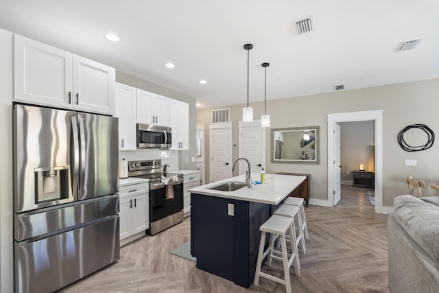 kitchen with a sink, white cabinets, stainless steel appliances, and visible vents