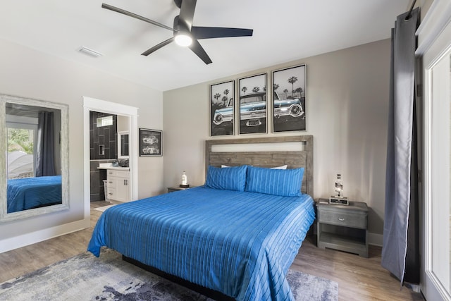 bedroom featuring baseboards, a ceiling fan, wood finished floors, and visible vents