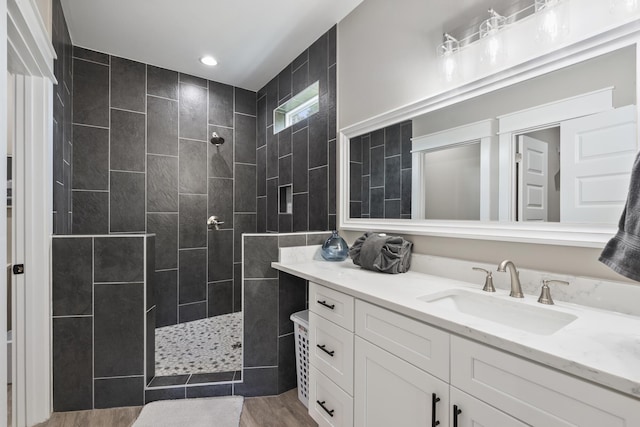 bathroom with a walk in shower, vanity, recessed lighting, and wood finished floors