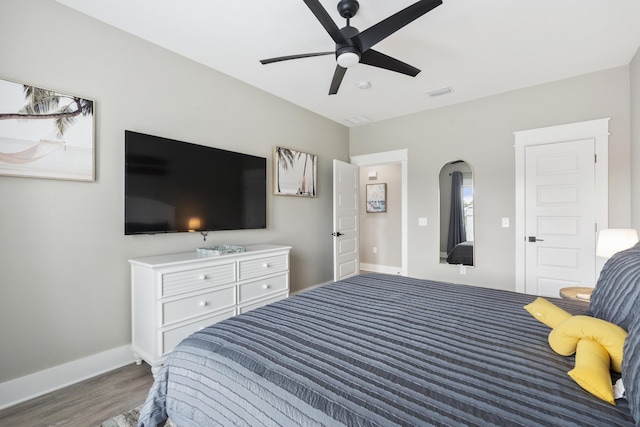 bedroom with visible vents, baseboards, ceiling fan, and wood finished floors