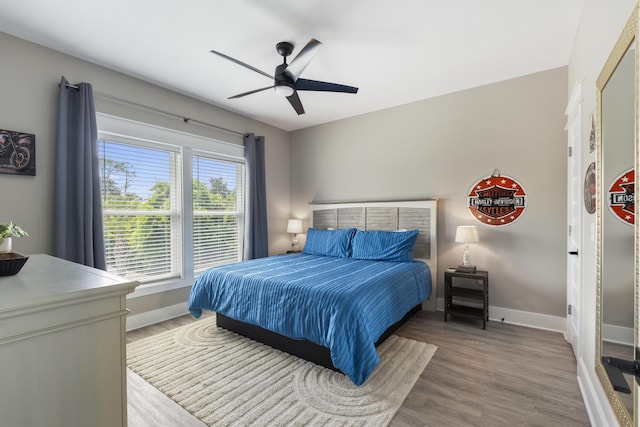 bedroom with baseboards, ceiling fan, and wood finished floors