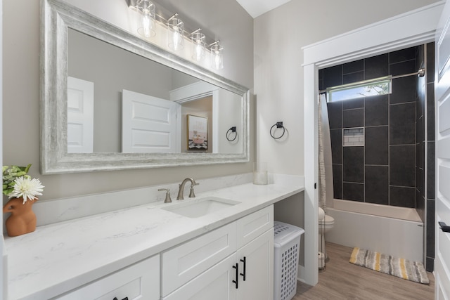 bathroom with toilet, shower / tub combination, wood finished floors, and vanity