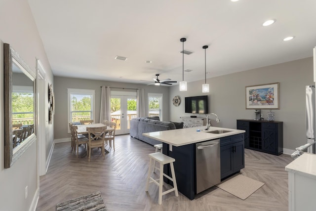 kitchen featuring visible vents, a sink, baseboards, light countertops, and stainless steel appliances