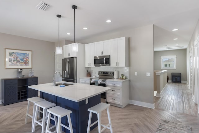 kitchen featuring baseboards, a sink, a kitchen breakfast bar, and stainless steel appliances