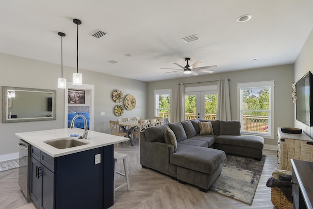 living area featuring baseboards, visible vents, a ceiling fan, and a wealth of natural light