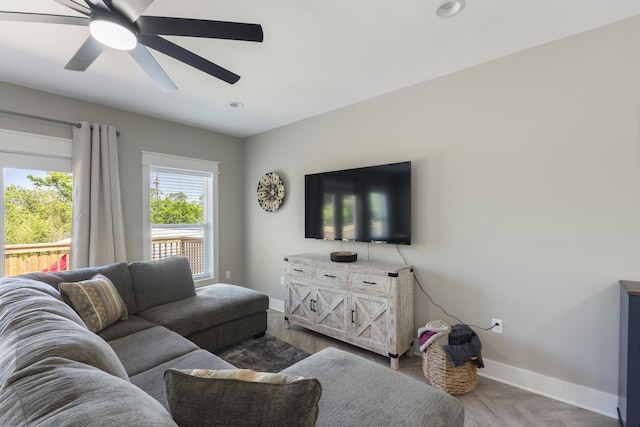 living room with baseboards, a ceiling fan, and recessed lighting