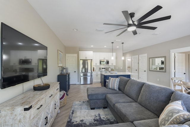 living area with a ceiling fan, recessed lighting, and light wood-style floors