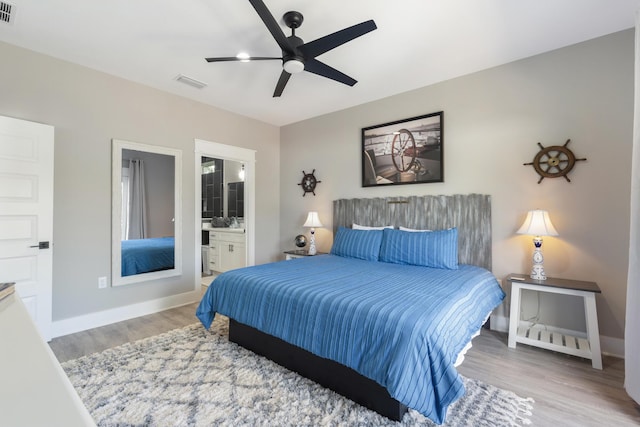 bedroom with baseboards, connected bathroom, light wood-style flooring, and visible vents