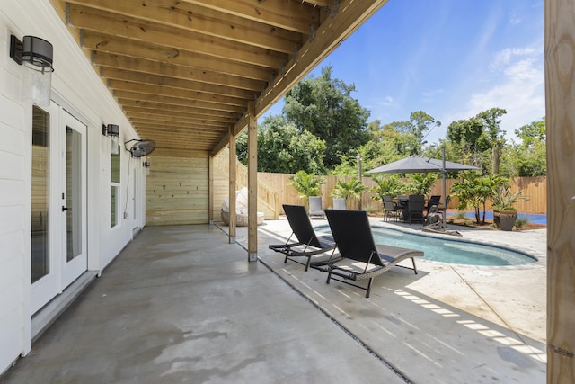 view of patio with french doors, a fenced backyard, and outdoor dining space