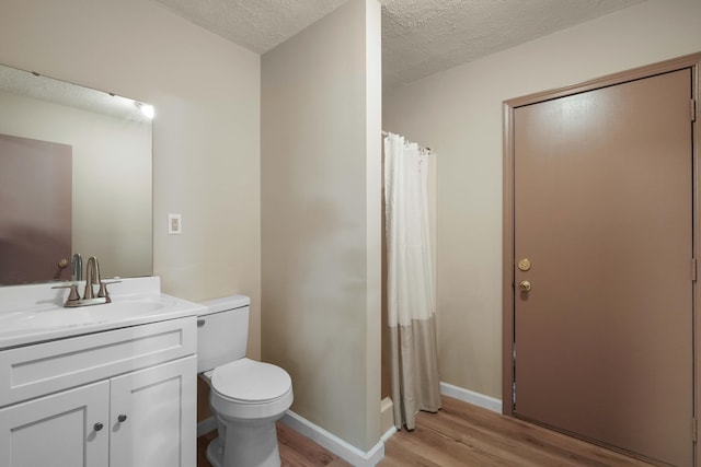 255 Brackin St, Crestview, FL 32539 - full bath with a textured ceiling, wood finished floors, vanity, baseboards, and toilet