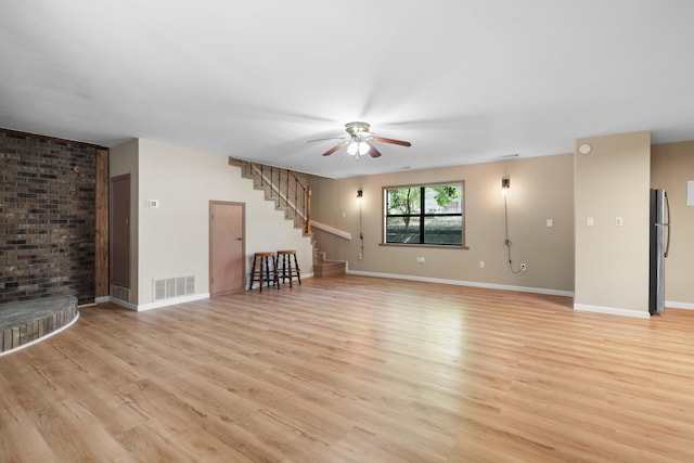 255 Brackin St, Crestview, FL 32539 - unfurnished living room with a ceiling fan, visible vents, baseboards, light wood finished floors, and stairs