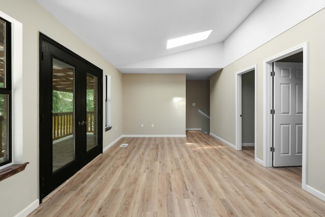 255 Brackin St, Crestview, FL 32539 - unfurnished room featuring visible vents, light wood-style floors, baseboards, vaulted ceiling with skylight, and french doors