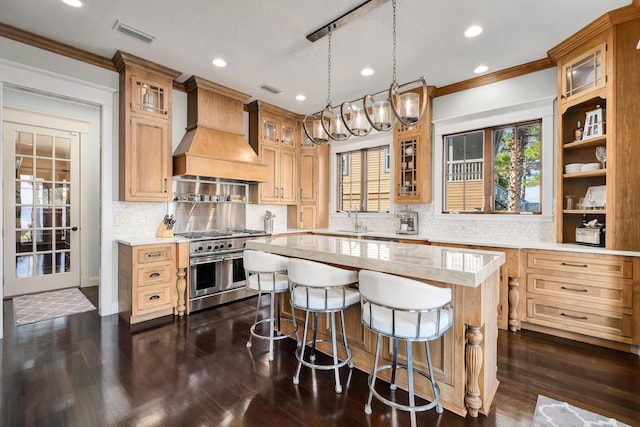 kitchen featuring crown molding, range with two ovens, custom exhaust hood, and a center island