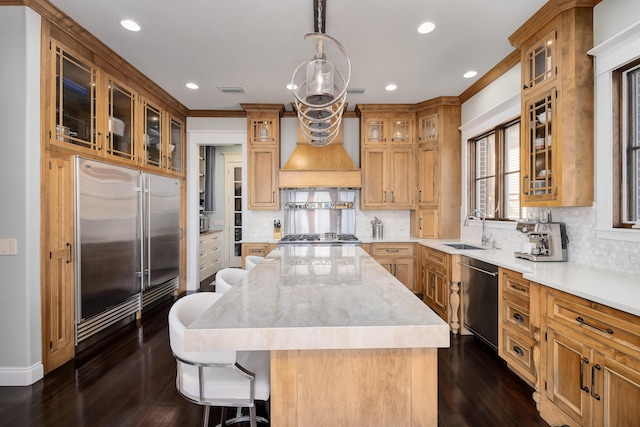 kitchen featuring a sink, dishwasher, a kitchen breakfast bar, backsplash, and a kitchen island