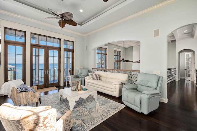 living area featuring french doors, arched walkways, ceiling fan, and wood finished floors