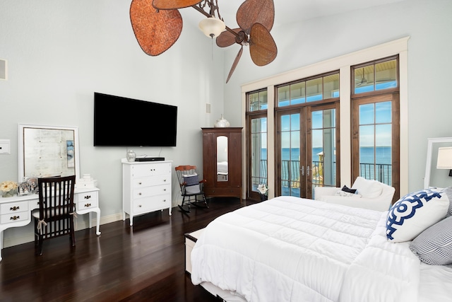 bedroom with french doors, a towering ceiling, wood finished floors, baseboards, and access to outside