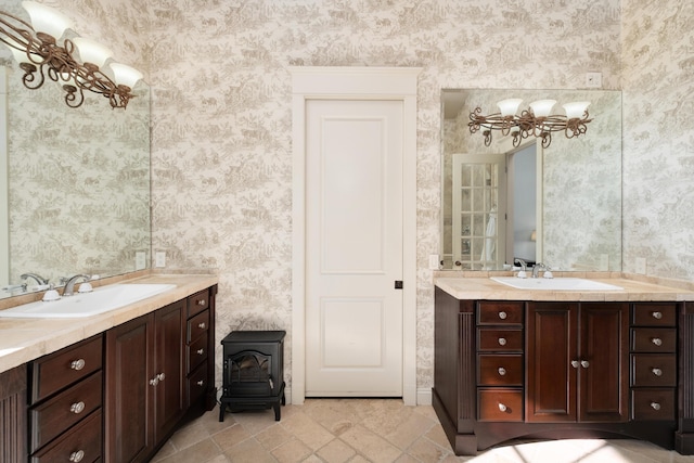 bathroom with a sink, a wood stove, and wallpapered walls