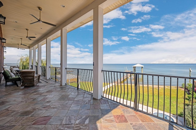 exterior space with a ceiling fan and a water view