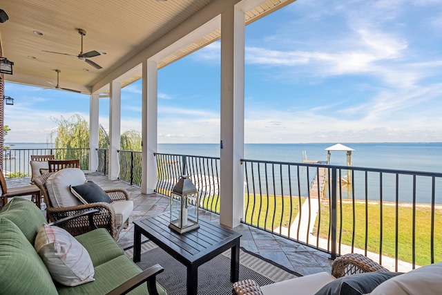 balcony with an outdoor living space, a water view, and ceiling fan