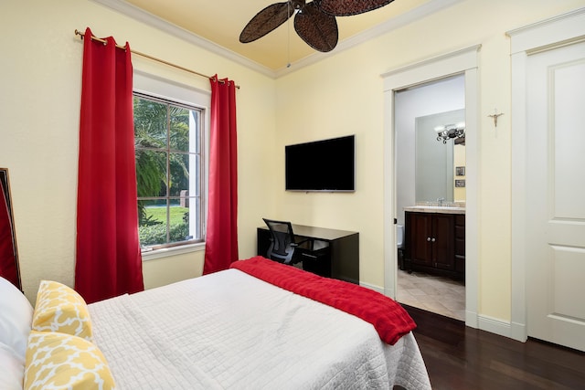 bedroom featuring ornamental molding, wood finished floors, baseboards, ensuite bathroom, and a sink