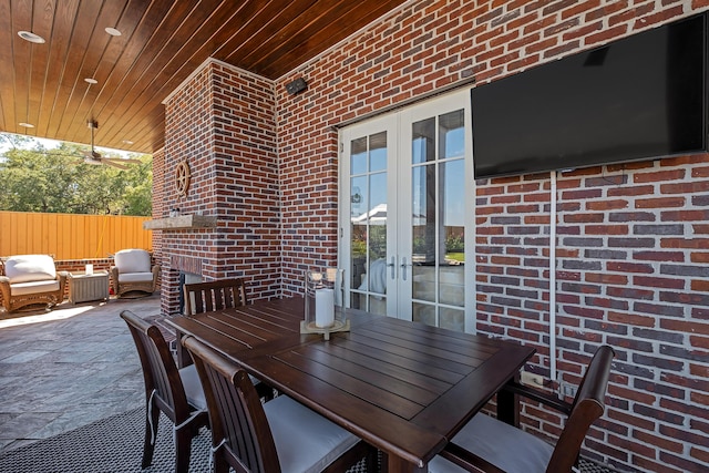 view of patio with outdoor dining area, fence, and french doors