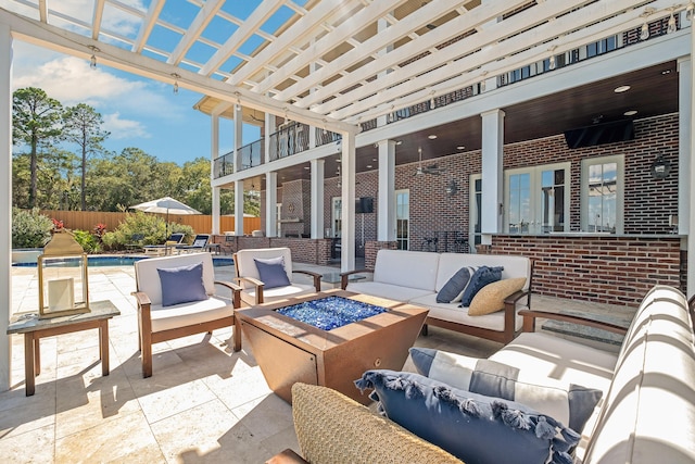 view of patio / terrace featuring a fenced in pool, fence, a balcony, and an outdoor living space with a fire pit
