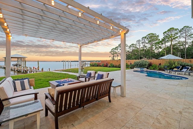 patio terrace at dusk with a lawn, a pergola, a water view, and an outdoor living space