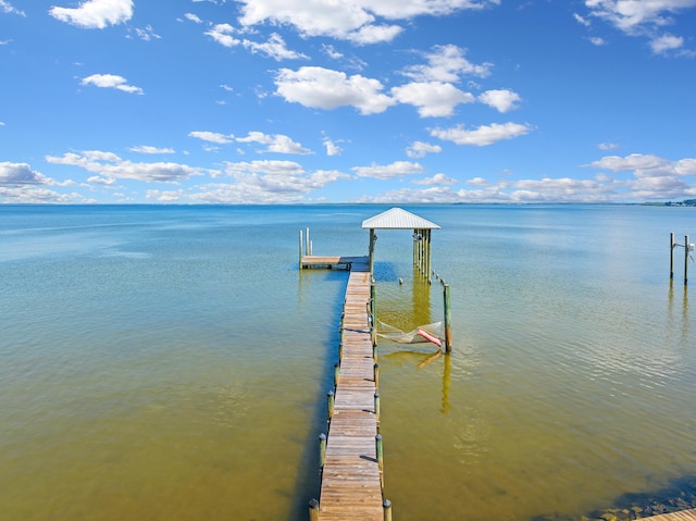 dock area featuring boat lift and a water view