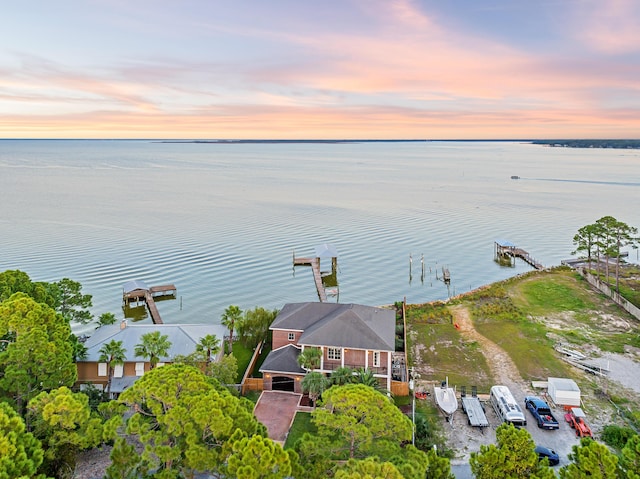 aerial view at dusk featuring a water view