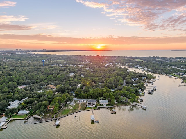 aerial view at dusk featuring a water view