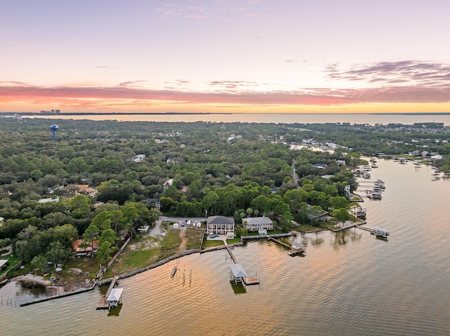aerial view at dusk featuring a water view