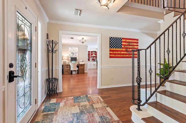 entryway with visible vents, ornamental molding, wood finished floors, and stairway