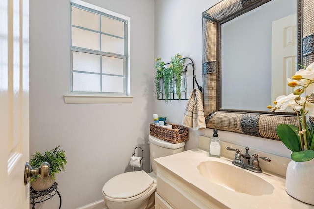 bathroom featuring vanity, baseboards, and toilet