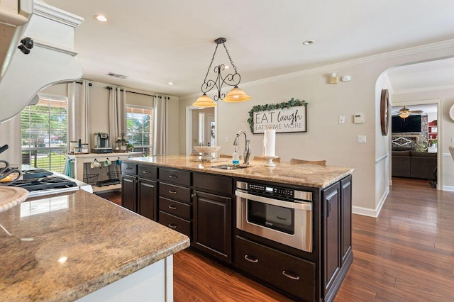 kitchen with a sink, dark brown cabinets, stainless steel oven, and visible vents
