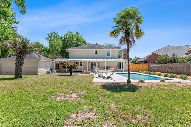 rear view of house with a yard, a fenced in pool, a fenced backyard, and a patio area