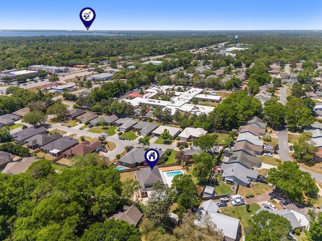drone / aerial view featuring a residential view and a wooded view