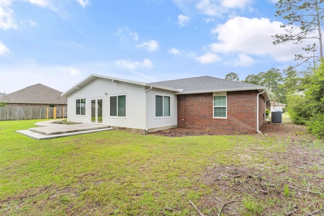 back of property with brick siding, fence, a patio area, cooling unit, and a lawn