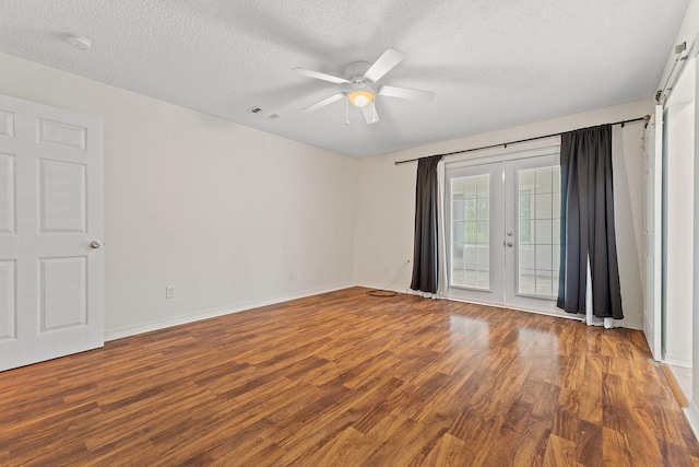 spare room with visible vents, ceiling fan, french doors, and wood finished floors