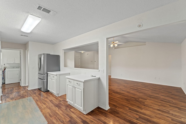 kitchen featuring visible vents, light countertops, freestanding refrigerator, washer / dryer, and a ceiling fan