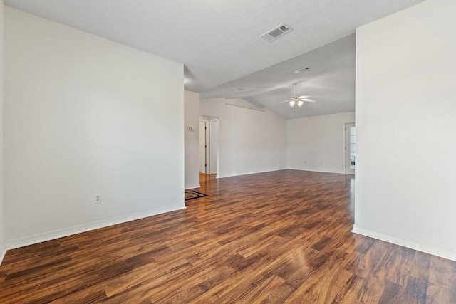 empty room featuring ceiling fan, visible vents, vaulted ceiling, baseboards, and wood finished floors